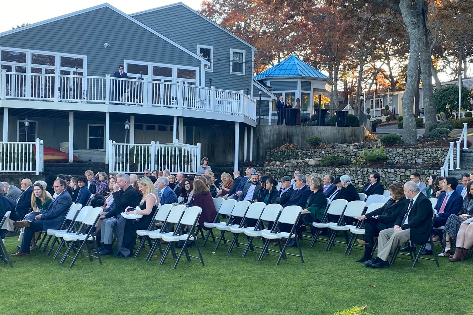 Guests seated on a lawn for an outdoor ceremony