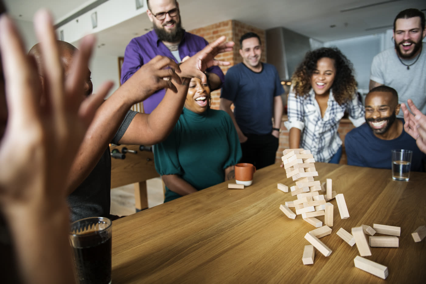 A table of friends laughing and reacting together during a game