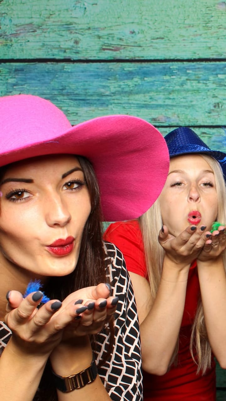 Four guests in props inside the photo booth