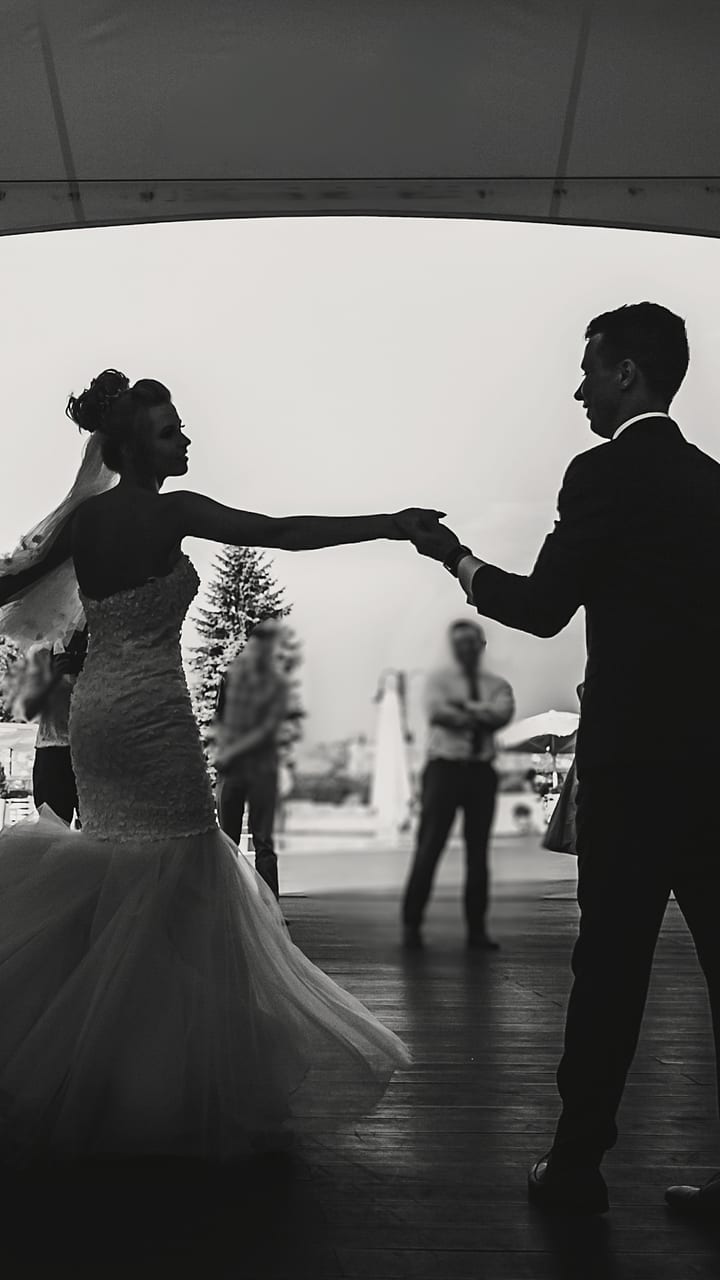 A couple dancing with their guests gathered around